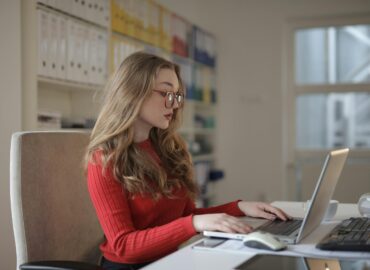 Woman in a office, writing on a laptop. Accountant office.